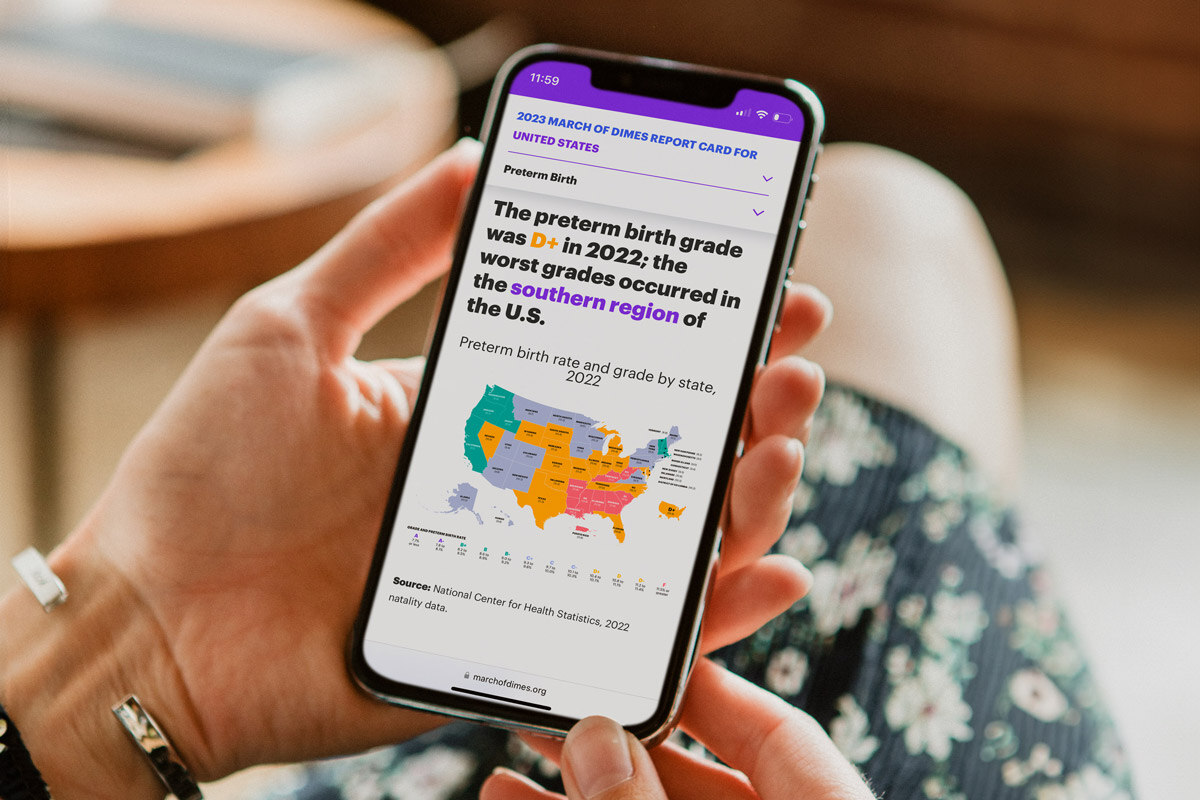Photo of woman holding a mobile phone that is displaying the March of Dimes Peristats website